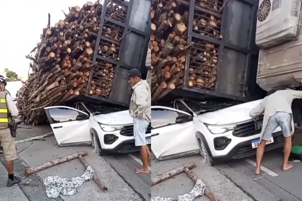  Caminhão tomba e carga de madeira cai sobre carro